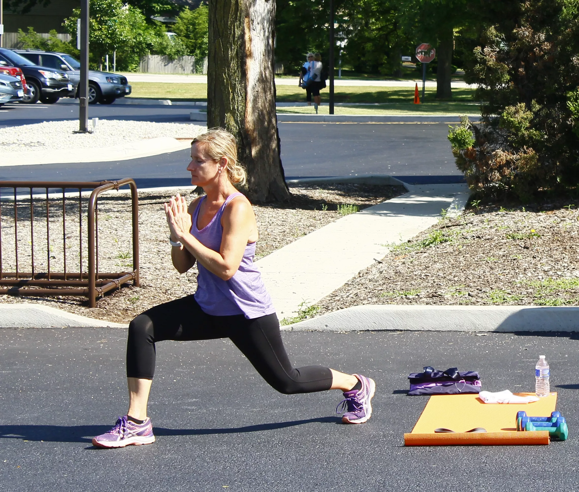 Small group exercise image. Woman doing yoga outside